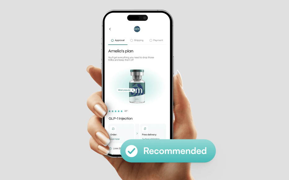 A hand holding a smartphone against a neutral gray background, displaying a mobile health app interface. The screen shows a personalized plan titled Amelia's plan for a GLP-1 injection, featuring a 3D render of a medical vial with a teal and navy logo. Above the phone, a large teal floating button with a white checkmark icon reads Recommended. The UI design is minimalist with teal accents and includes progress indicators for Approval, Shipping, and Payment.